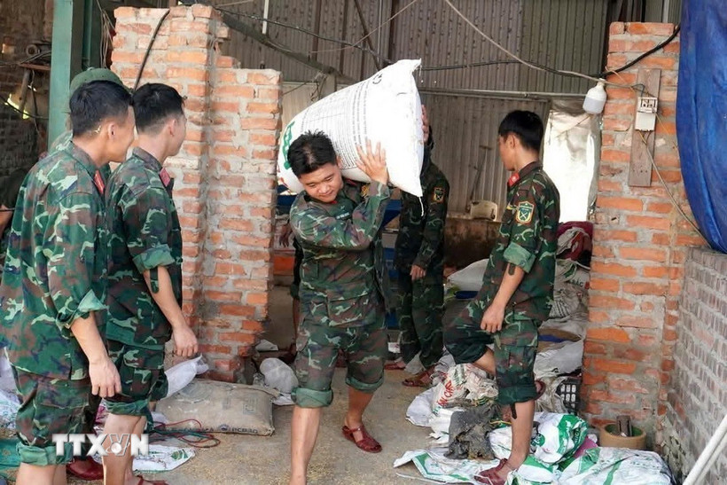 Cán bộ, chiến sỹ Sư đoàn 304 hỗ trợ người dân xã Bình Nguyên di chuyển tài sản đến nơi an toàn. (Ảnh: TTXVN phát)