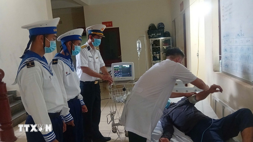 Bác sỹ Bệnh xá đảo Trường Sa kiểm tra sức khỏe bệnh nhân Lê Văn Đông. (Ảnh: TTXVN phát)