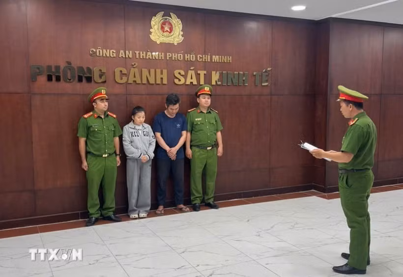 Cơ quan điều tra tống đạt quyết định bắt giữ các đối tượng. (Ảnh: TTXVN phát)