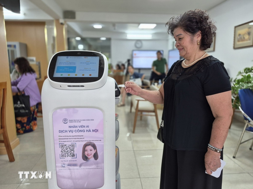 Người dân trải nghiệm Robot AI áp dụng công nghệ trí tuệ nhân tạo hỗ trợ thực hiện các thủ tục hành chính ở phường Cửa Nam. (Ảnh: Nguyễn Thắng/TTXVN)