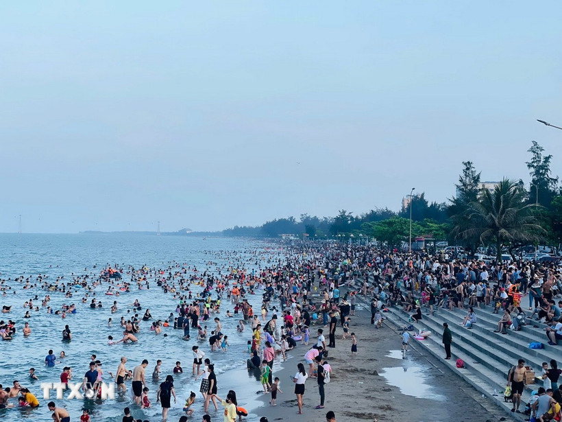 Dọc bờ biển Cửa Lò trong xanh kéo dài gần 10km đông nghịt người. (Ảnh: Bích Huệ/TTXVN)