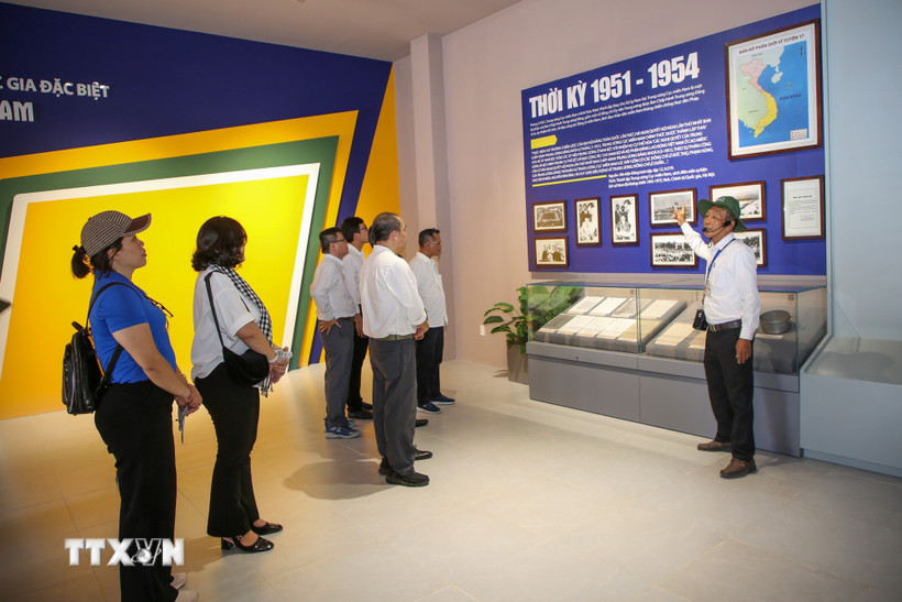 Du khách lắng nghe thuyết minh về vai trò lịch sử của Căn cứ Trung ương Cục miền Nam trong kháng chiến chống Mỹ. (Ảnh: Giang Phương/TTXVN)