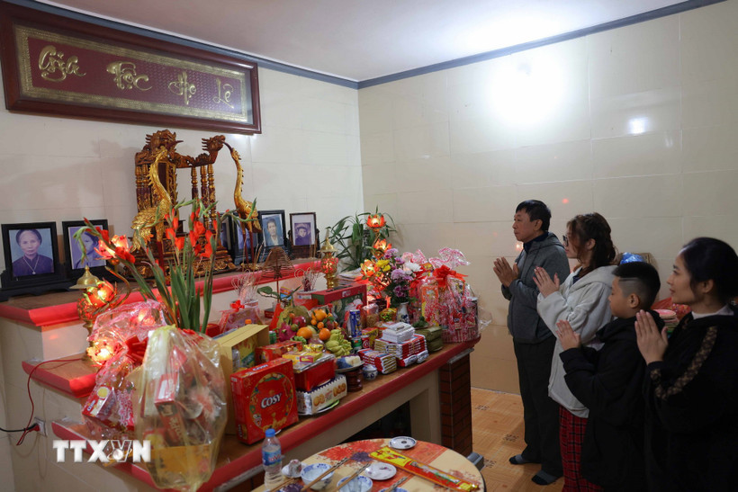 Sau khoảnh khắc giao thừa, bước sang năm mới, con cháu thắp hương thành kính mong tổ tiên phù hộ. (Ảnh: Thanh Tùng/TTXVN)