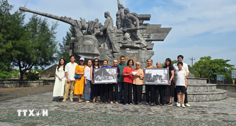 Gia đình nhà báo, liệt sỹ Lương Nghĩa Dũng tặng các nữ pháo thủ của Đại đội nữ pháo binh Ngư Thủy 2 bức ảnh tư liệu. (Ảnh: TTXVN phát)