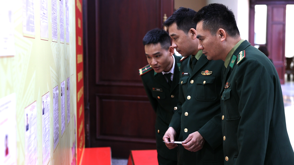 Cán bộ, chiến sĩ Bộ đội Biên phòng nghiên cứu danh sách ứng cử viên trước khi bỏ phiếu. (Ảnh: Dương Linh/Vietnam+)