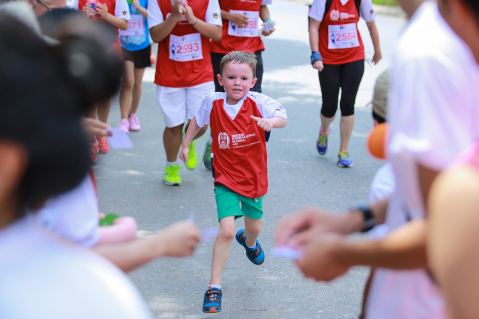 Một cậu bé mặt đỏ gay cố gắng về đích trong tiếng reo hò của mọi người. (Ảnh: Minh Sơn/Vietnam+)