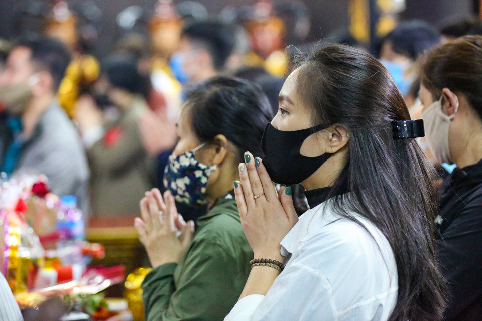 Việc thực hiện giãn cách tối thiểu giữa người với người rất khó thực hiện khi số lượng người dân đến chùa rất đông. (Ảnh: Minh Sơn/Vietnam+)