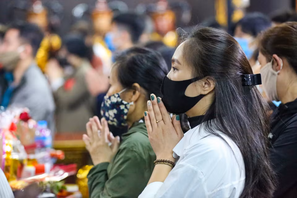 Việc thực hiện giãn cách tối thiểu giữa người với người rất khó thực hiện khi số lượng người dân đến chùa rất đông. (Ảnh: Minh Sơn/Vietnam+)