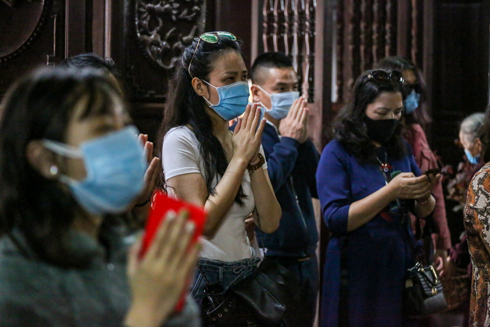 Trong lúc hành lễ, mọi người vẫn phải thực hiện nghiêm quy định đeo khẩu trang trong chùa. (Ảnh: Minh Sơn/Vietnam+)