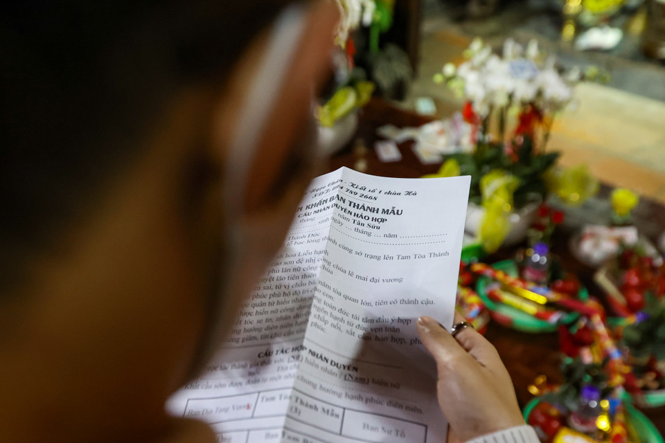 Văn khấn được thảo sẵn, mọi người chỉ cần điền tên, tuổi, địa chỉ, mong muốn tác hợp nhân duyên và khấn trước Ban Mẫu. (Ảnh: Minh Sơn/Vietnam+)