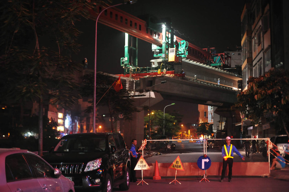 Tại khu vực thi công lắp ghép dầm bê tông, các công nhân sẽ hướng dẫn các phương tiện đổi hướng di chuyển khỏi khu vực nguy hiểm. (Ảnh: Minh Sơn/Vietnam+)