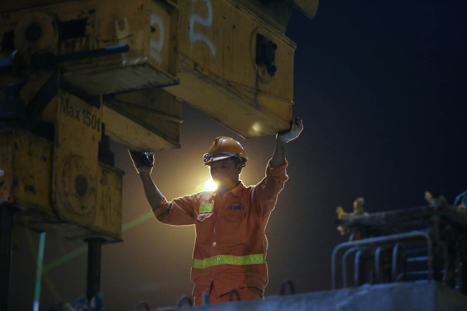 Có khoảng 15 công nhân phụ trách việc thi công và lắp đặt bao gồm công nhân điện, thợ lắp đặt và thi công để lao dầm, chưa kể một đội vận chuyển bên dưới. (Ảnh: Minh Sơn/Vietnam+)