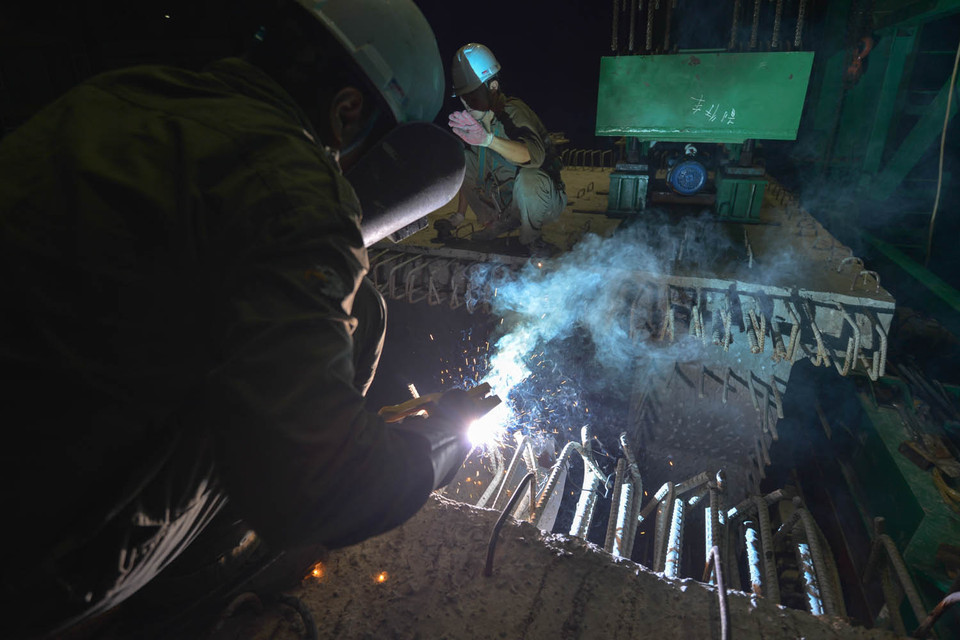 Công nhân đang hoàn thành nốt các công đoạn cuối của quá trình lắp đặt dầm bê tông. (Ảnh: Minh Sơn/Vietnam+)