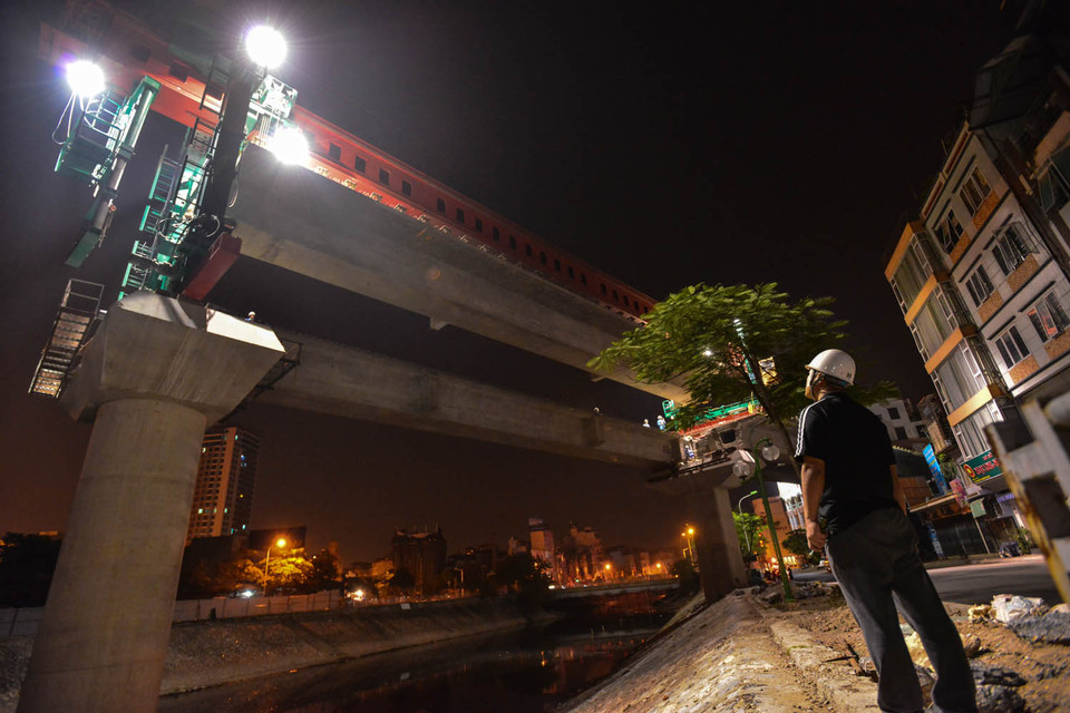 Theo ông Lê Văn Dương (Phó Tổng giám đốc ban quản lý dự án đường sắt trên cao) cho biết, quá trình vận chuyển dầm qua sông Tô Lịch sẽ qua cả nhà dân với khoảng cách rất hẹp nên công tác an toàn phải tuyệt đối, bất cứ một sơ sẩy nào cũng gây ra hậu quả nặng nề. (Ảnh: Minh Sơn/Vietnam+)