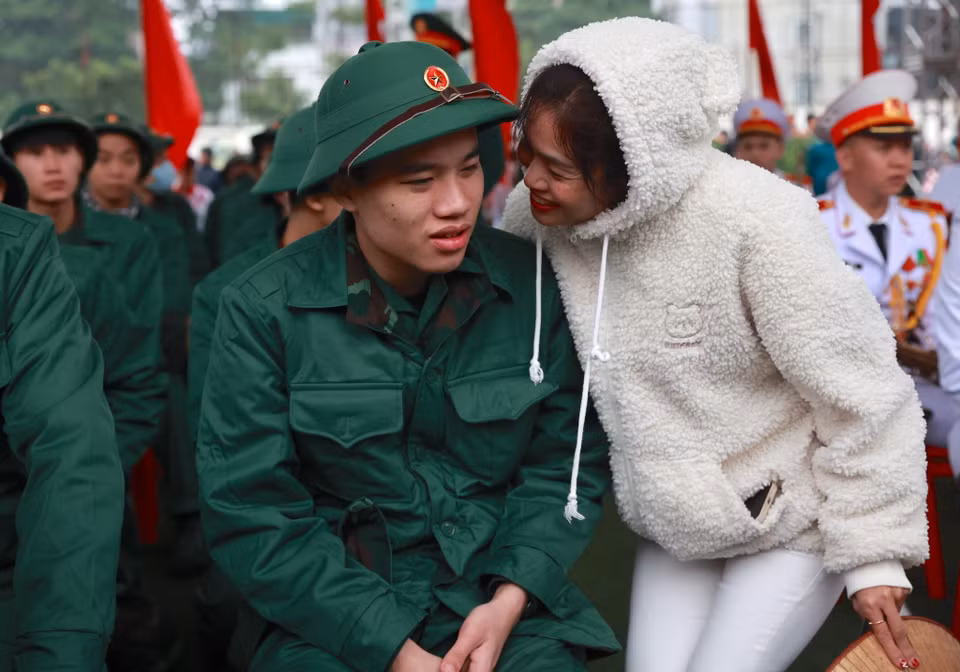 Chị Phạm Thị Hiền đưa con trai là Phạm Đoàn Trung đến địa điểm giao nhận quân quận Đống Đa. Chị chia sẻ: “Con khi về nhà nói với bố mẹ là mong muốn đi nhập ngũ, cả nhà đều ủng hộ vì gia đình có truyền thống trong ngành lực lượng vũ trang. Trước ngày lên đường mất 2 đêm tôi không ngủ được, tôi đã khóc bởi cả đời con chưa xa mẹ bao giờ, nhưng đến hôm nay tôi cảm thấy rất vui và tự hào khi con mặc lên người bộ quân phục. Mong rằng thời gian thực hiện nghĩa vụ sẽ giúp con trưởng thành, mạnh mẽ hơn." (Ảnh: Minh Sơn/Vietnam+)
