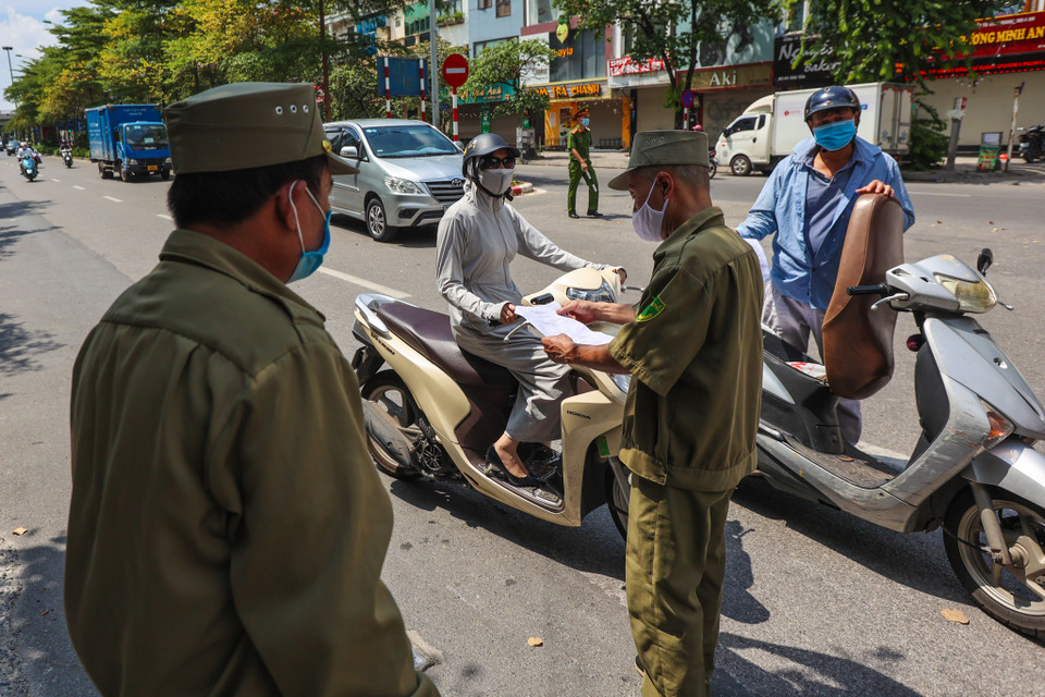 Những người dân đi qua sẽ phải xuất trình được giấy tờ chứng minh ra ngoài làm việc trong khuôn khổ cho phép của Chỉ thị 17. (Ảnh: Minh Sơn/Vietnam+)