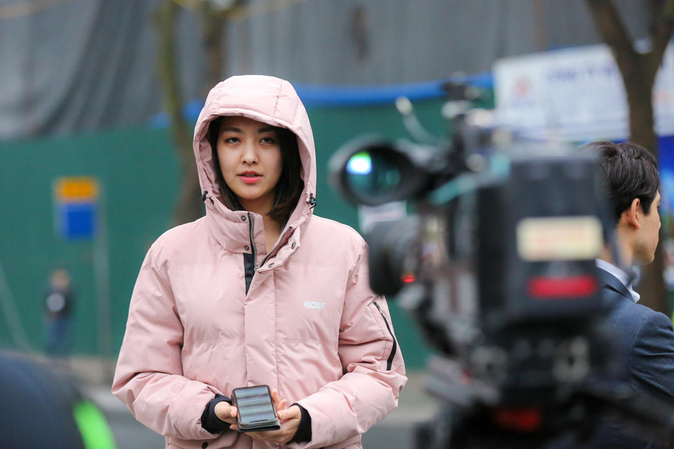 Nữ phóng viên Hee-jun Christine Park – đài Arirang đang đưa tin tại 'điểm nóng' khách sạn Melia trong thời tiết khá lạnh vào buổi sáng của Hà Nội. (Ảnh: Minh Sơn/Vietnam+)