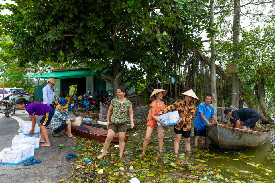Ông Bích cũng chia sẻ, mặc dù đã huy động cả xóm hỗ trợ vận chuyển đồ đạc lên cao nhưng nước lũ lên quá nhanh, cùng với việc không có thuyền lớn để chở, nhiều nhà đã ngập hết toàn bộ đồ đạc. Cả xóm cũng bị cô lập toàn phần với xã, không có điện, không có nước sạch, lương thực thực phẩm cũng phải nhờ tới ban cứu trợ. (Ảnh: Minh Sơn/Vietnam+)