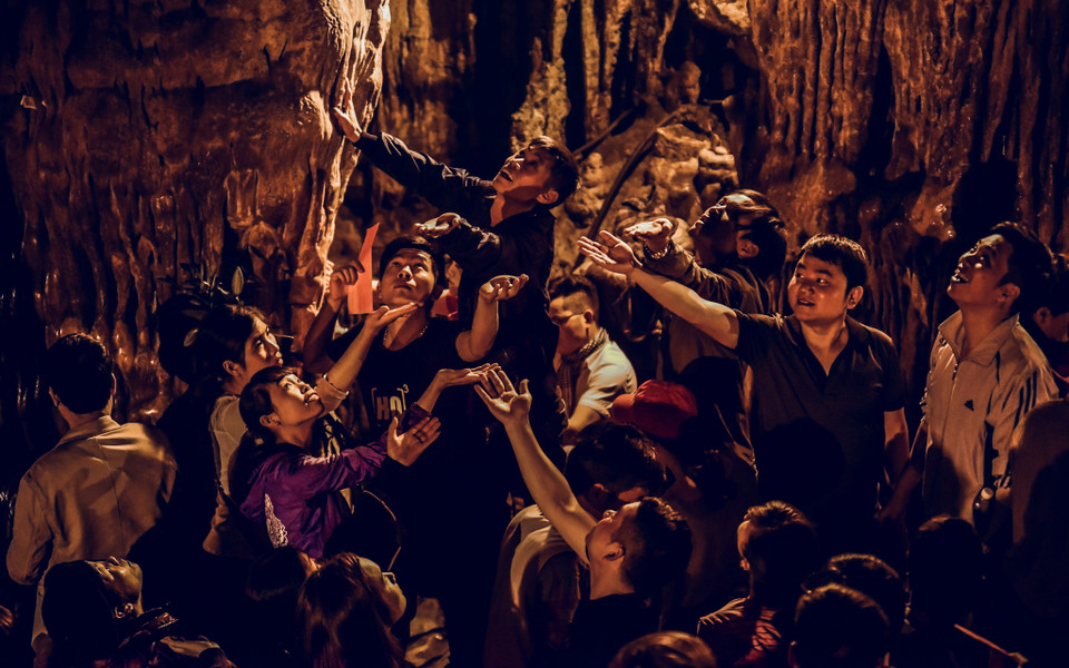 Du khách thập phương chen nhau hứng những giọt nước trong động chùa Hương. Họ cho rằng nếu nhận được nước từ thạch nhũ cả năm sẽ may mắn. (Ảnh: PV/Vietnam+)