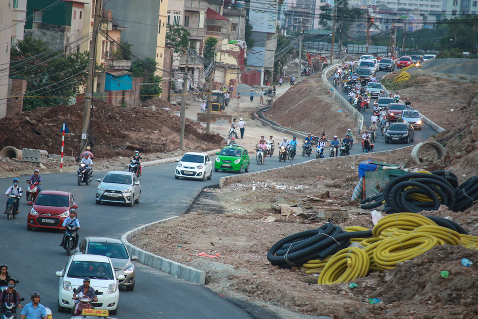 Người dân sẽ di chuyển theo tuyến đường gom trái song song với đường Bưởi đã bị rào chắn. (Ảnh: Minh Sơn/Vietnam+)