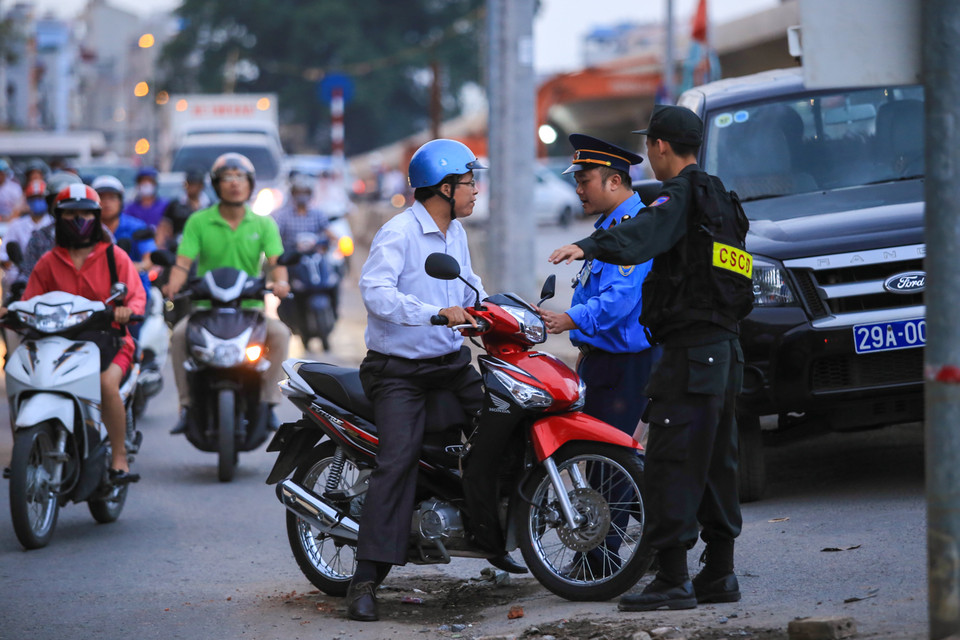 Một số người dân cố tình lao lên dốc mặc cho lực lượng chức năng ngăn cản. (Ảnh: Minh Sơn/Vietnam+)