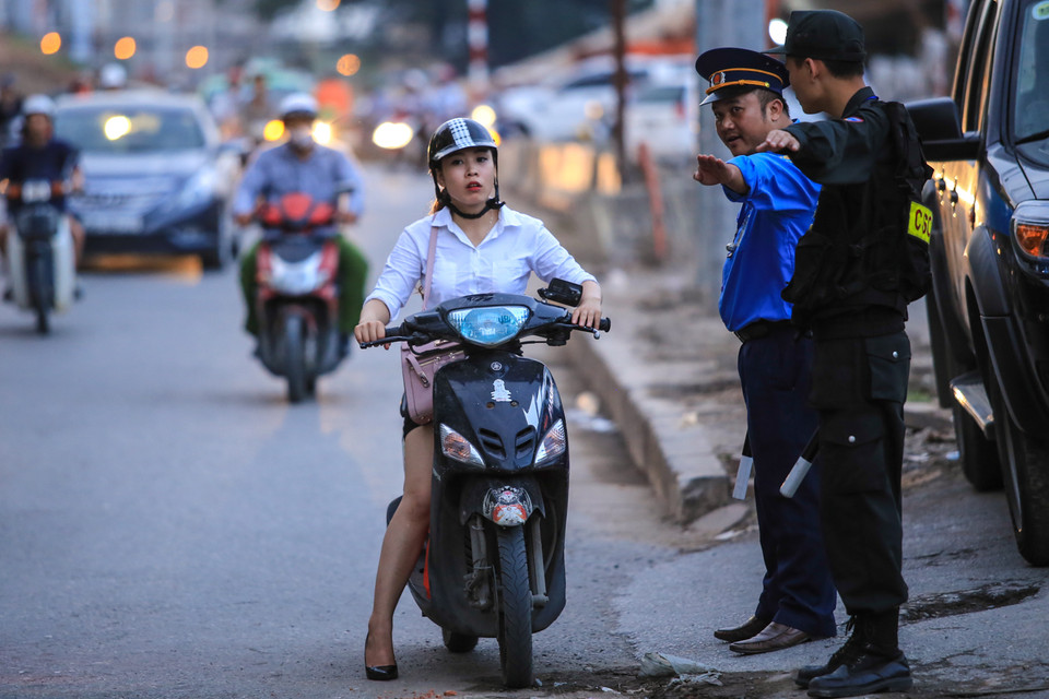 Một số người dân ngỡ ngàng khi đường dốc rẽ lên Bưởi bị cấm và được lực lượng chức năng chỉ dẫn đi đúng hướng. (Ảnh: Minh Sơn/Vietnam+)