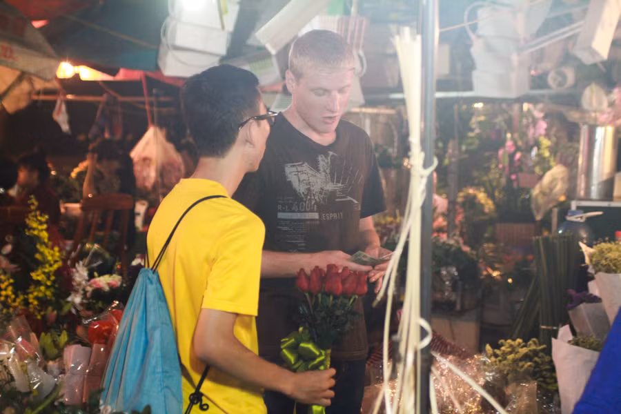 Trong các đấng mày râu có cả những anh chàng Tây cũng đi chọn lựa hoa về làm quà tặng cho người yêu mình. (Ảnh Minh Sơn/Vietnam+)