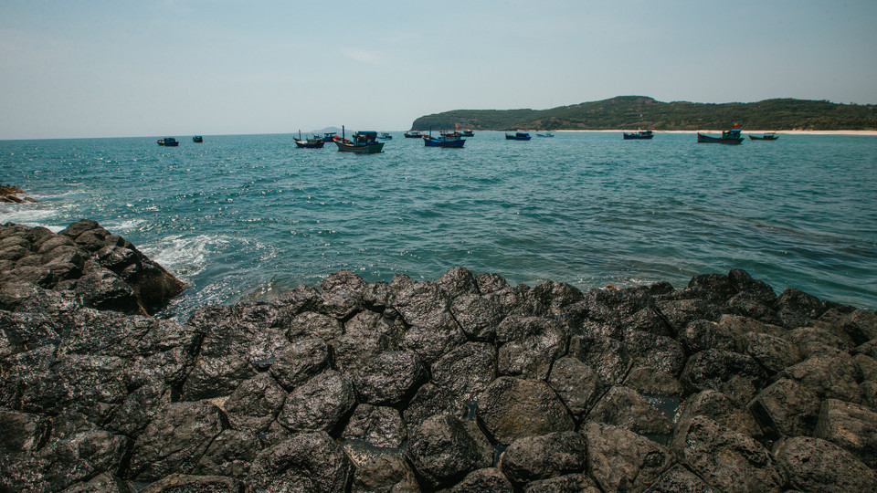 Màu đen bí ẩn của đá nổi lên trên màu xanh trong veo của nước biển tạo nên khung cảnh quyến rũ khó cưỡng. (Ảnh: Minh Sơn/Vietnam+)