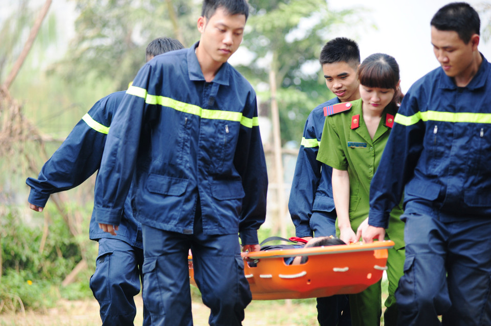 Thượng sĩ Nguyễn Thị Thanh Hòa hỗ trợ đồng đội cứu hộ người bị thương do ngạt khói trong một bài tập huấn luyện. (Ảnh: Minh Sơn/Vietnam+)