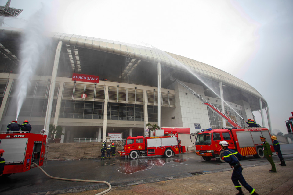 Cảnh sát Phòng cháy chữa cháy thực hiện công tác dập lửa đồng thời giải cứu rất nhiều người dân bị mắc kẹt trên tầng thượng. (Ảnh: Minh Sơn/Vietnam+)