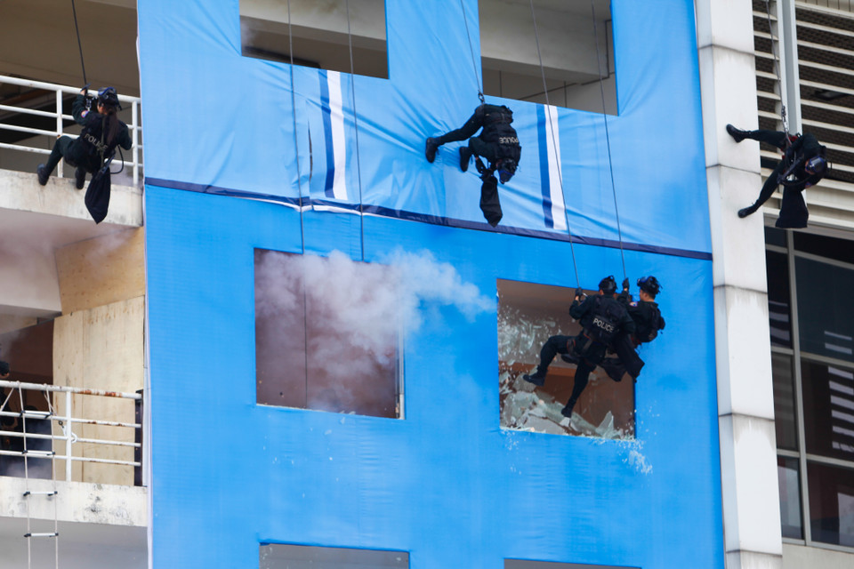 Trước tình thế nguy nan, lực lượng cảnh sát đặc nhiệm đã áp sát từ tầng thượng tòa nhà xuống, đạp vỡ cửa kính để giải cứu con tin. (Ảnh: Minh Sơn/Vietnam+)