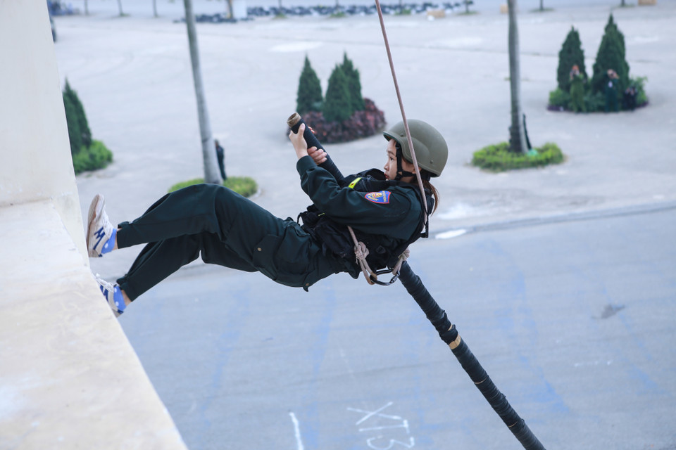 Nữ cảnh sát đặc nhiệm sử dụng sào để đột kích lên tầng 3, được giả định là nơi nhóm khủng bố giữ con tin. (Ảnh: Minh Sơn/Vietnam+)