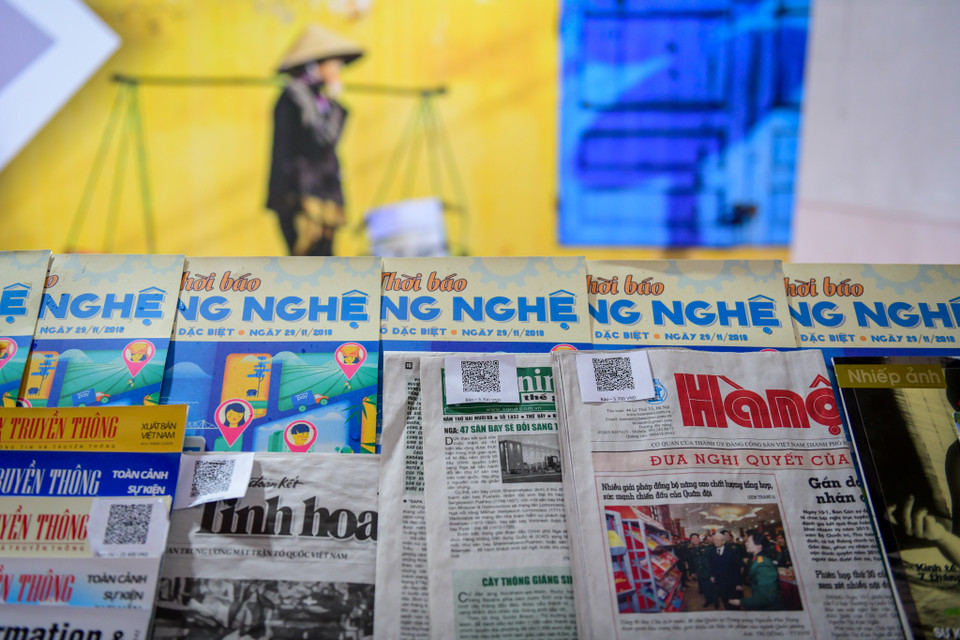 Người dùng khi mua báo sẽ không cần trả tiền mặt mà sẽ trả bằng ví điện tử thông qua các mã QR Code gắn trên tờ báo. (Ảnh: Minh Sơn/Vietnam+)