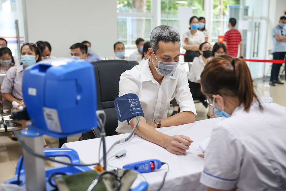 Các bàn đăng ký tiêm, khám sàng lọc trước tiêm đảm bảo tiêu chuẩn giãn cách của Bộ Y tế. (Ảnh: Minh Sơn/Vietnam+)