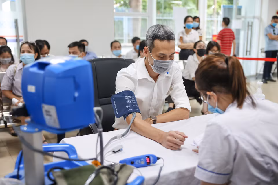 Các bàn đăng ký tiêm, khám sàng lọc trước tiêm đảm bảo tiêu chuẩn giãn cách của Bộ Y tế. (Ảnh: Minh Sơn/Vietnam+)