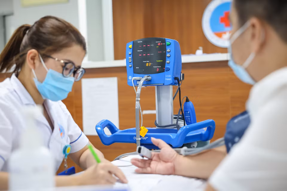 Người đi tiêm sẽ được đo huyết áp, đảm bảo sức khoẻ đủ điều kiện tiêu chuẩn mới được tiêm vaccine. (Ảnh: Minh Sơn/Vietnam+)