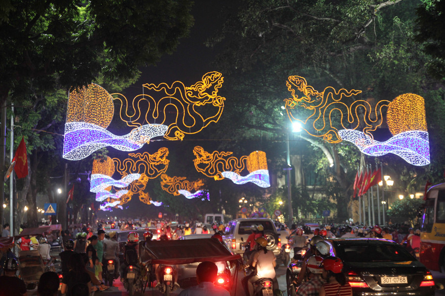 Về đêm, khu vực Hồ Gươm càng nổi bật hơn với những đèn, hoa, biểu ngữ thắp sáng. (Ảnh Minh Sơn/Vietnam+)