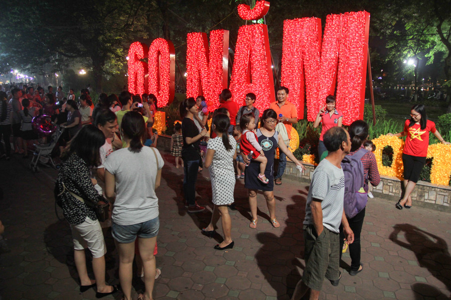 Chữ 60 năm được tết từ hàng ngàn bông hoa trở thành một điểm nổi bật thu hút người dân đến chụp ảnh. (Ảnh Minh Sơn/Vietnam+)