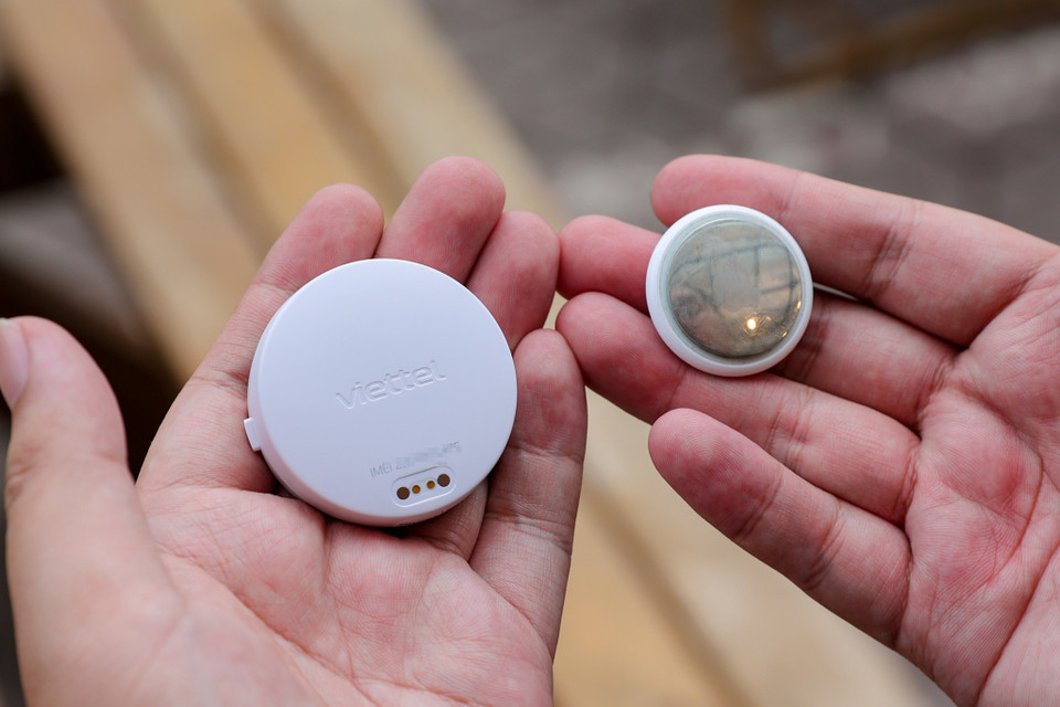 vTag được thiết kế hình tròn, có vỏ ngoài bằng nhựa. Mặt trước của vTag có logo và đèn báo hiệu cho việc liên kết thiết bị với ứng dụng. Cạnh bên có một nút cứng, bấm 2 lần để liên kết app, bấm giữ 2 giây để kích hoạt cảnh báo SOS. (Ảnh: Minh Sơn/Vietnam+)