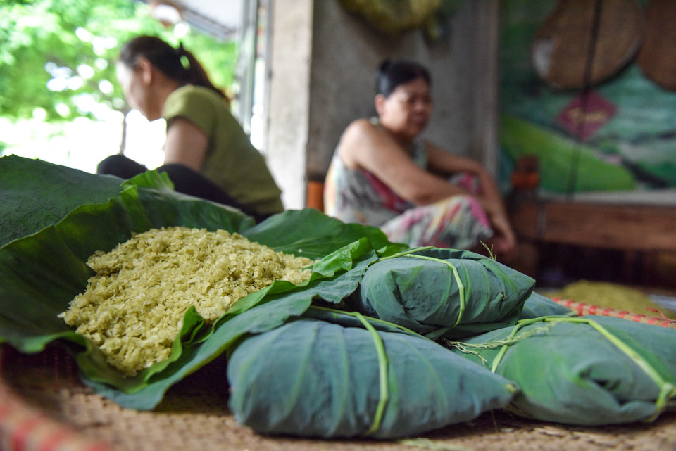 Cứ dịp cuối tháng 9 đầu tháng 10 hàng năm, những người làm cốm ở làng Mễ Trì (quận Nam Từ Liêm, Hà Nội) lại tất bật từ sáng sớm đến tận đêm khuya để kịp làm những mẻ cốm thơm dẻo cho khách. (Ảnh: PV/Vietnam+)