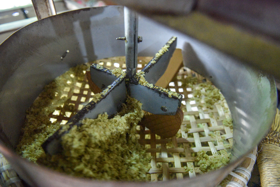 Cốm đang trong công đoạn sàng sảy. (Ảnh: PV/Vietnam+)