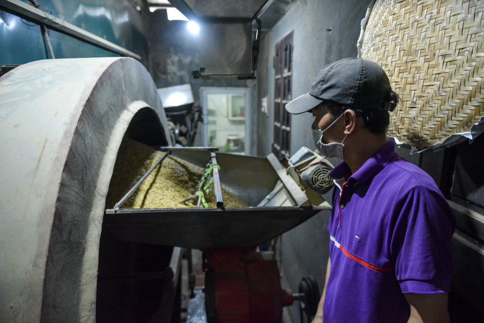 Khi bắt đầu rang người làm cốm để to lửa, khi cốm tái thì phải giảm lửa, bởi nếu lửa to quá sẽ bị cháy và lửa nhỏ quá cốm sẽ không đạt yêu cầu dẻo. (Ảnh: PV/Vietnam+)