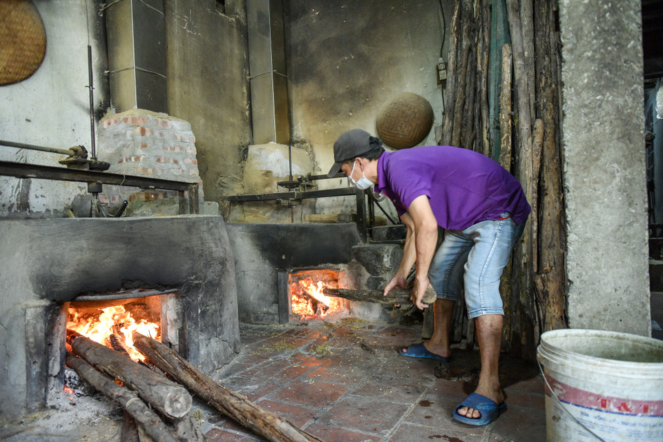 Cốm rang xong sẽ được xát vỏ rồi phải mang giã ngay, không được để nguội. (Ảnh: PV/Vietnam+)