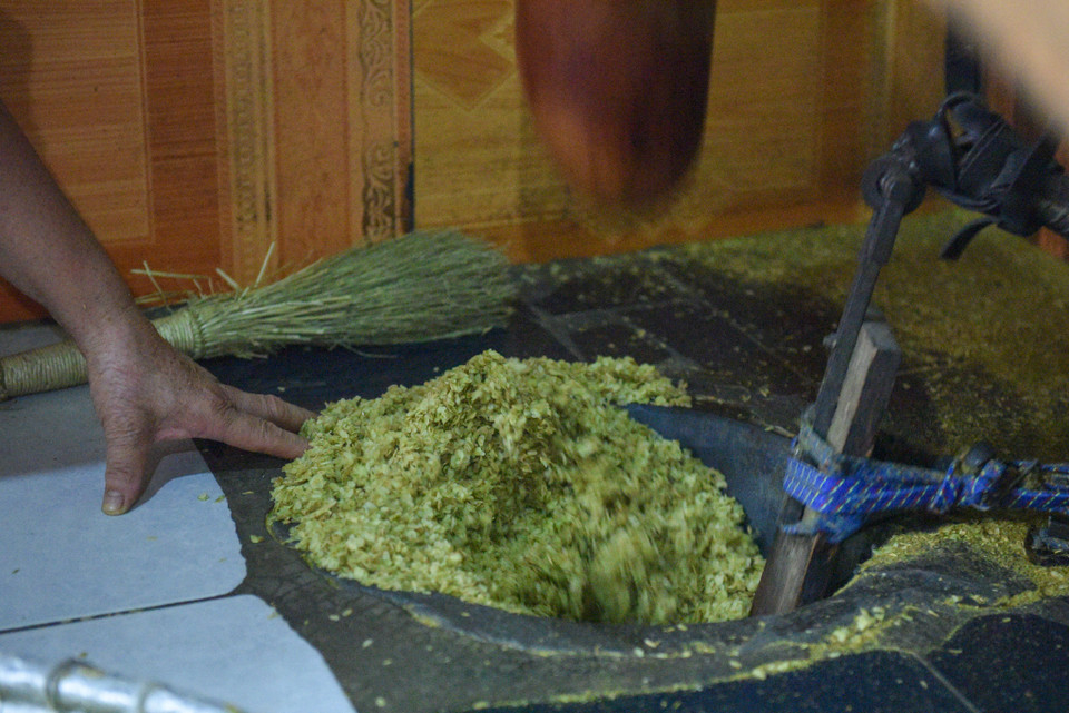 Công đoạn giã đòi hỏi hạt cốm vừa mỏng, vừa tơi, hạt cốm vẫn giữ nguyên, tỷ lệ 10kg thóc thì được 1,6-1,7kg cốm. (Ảnh: PV/Vietnam+)