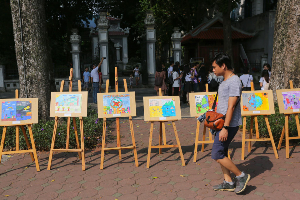 Trên không gian phố đi bộ Hồ Gươm nhiều người dân tỏ ra hào hứng khi được thưởng thức một triển lãm tranh đặc biệt của những học sinh trường Marie Curie. (Ảnh: Minh Sơn/Vietnam+)