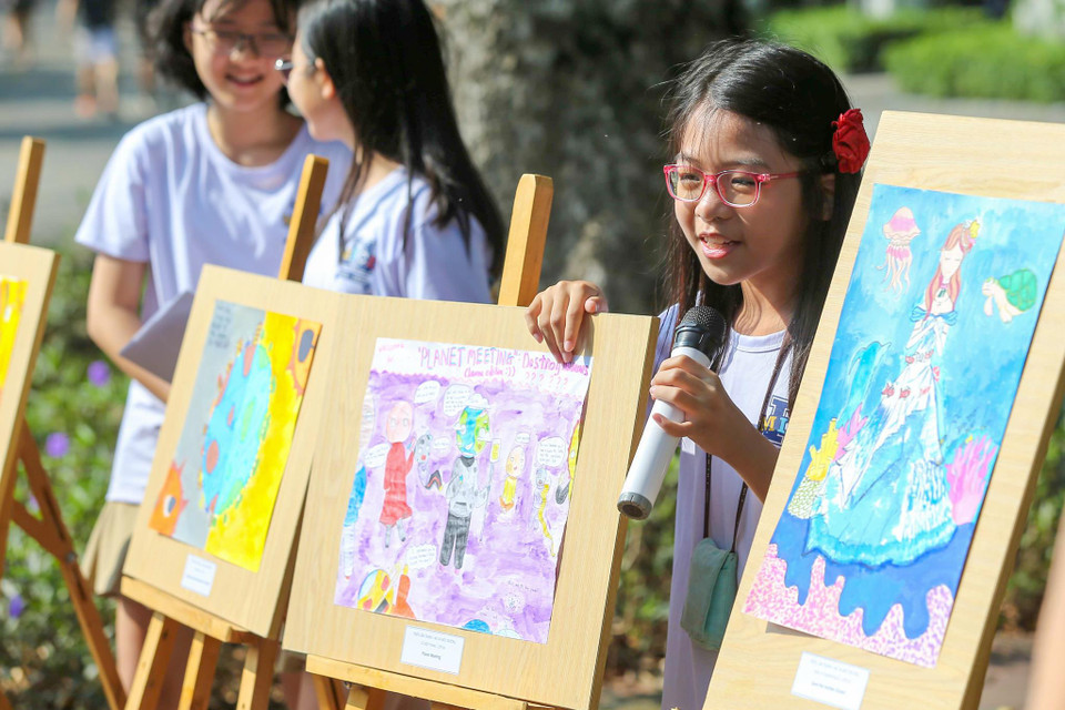 Bạn Lã Diệp Trang, học sinh lớp 6I1 đang chia sẻ với mọi người bức tranh với chủ đề Planet Meeting. (Ảnh: Minh Sơn/Vietnam+)