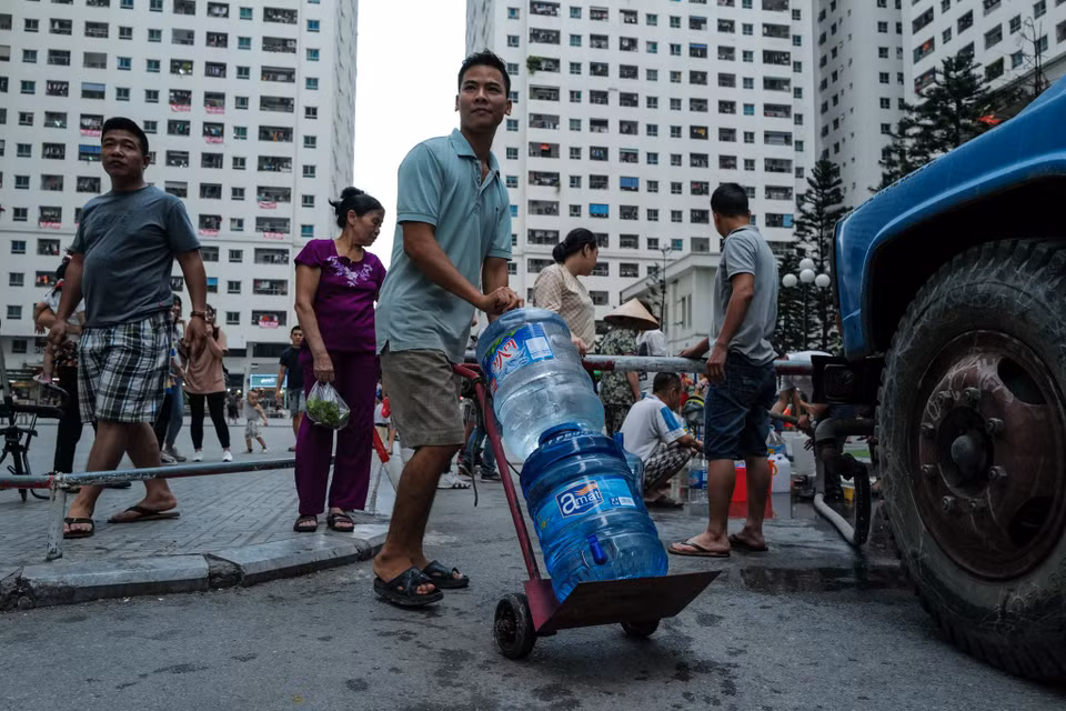 Người mang bình, xô, can… hay bất kì thứ gì có thể đựng được nước. (Ảnh: PV/Vietnam+)