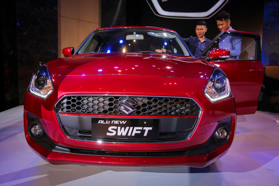 Chiếc Suzuki Swift màu đỏ thuộc phiên bản cao cấp GLX. Chiếc xe màu đỏ phiên bản cao cấp hơn có cụm đèn trước tích hợp dải LED định vị ban ngày. (Ảnh: Minh Sơn/Vietnam+)
