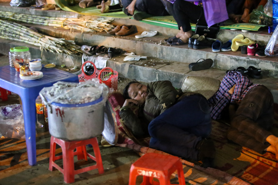 Những người bán hàng cũng chọn cách ngủ lại qua đêm để trông hàng. (Ảnh: Minh Sơn/Vietnam+)