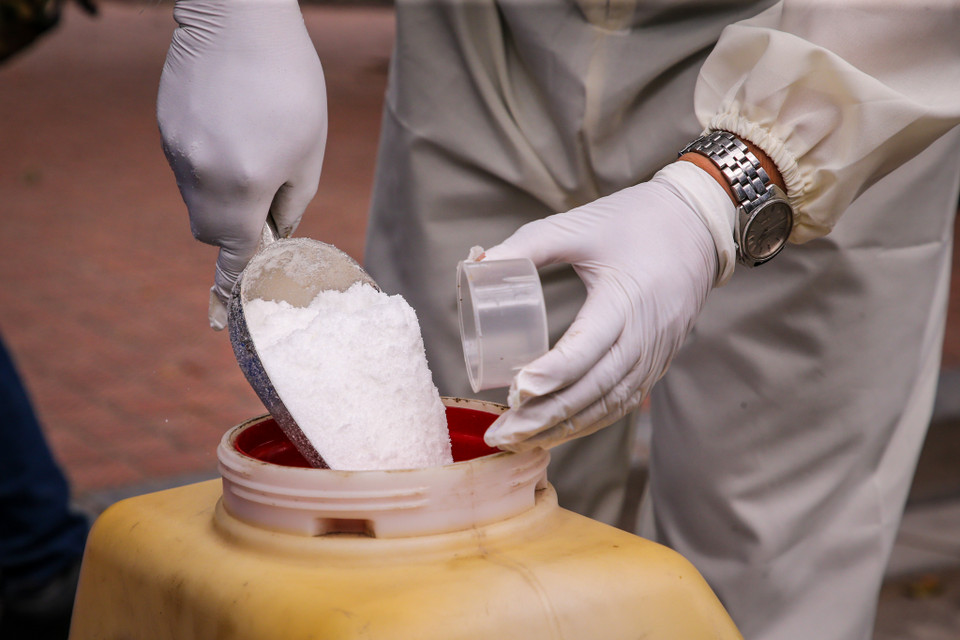 3 nhân viên sẽ thay phiên nhau tiến hành tẩy rửa, khử trùng bằng 300 - 350gram bột Cloramin B pha loãng. (Ảnh: Minh Sơn/Vietnam+)